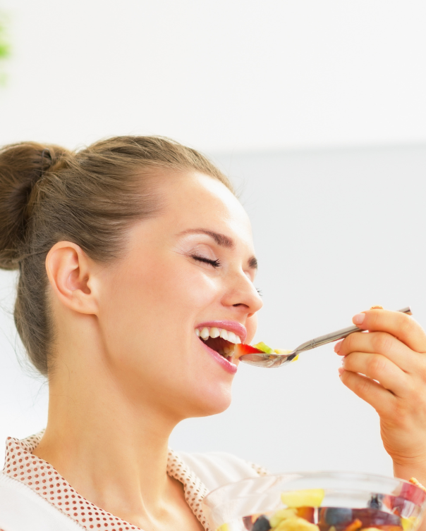 women eating mindfully a bowl of healthy fruits